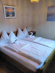 1 cama con sábanas blancas y almohadas en una habitación en Apartment Grace, Mountain view, en Kaprun