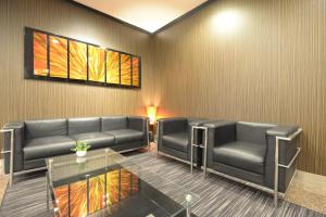 a waiting room with two leather couches and a table at APA Hotel Isehara-Ekimae in Isehara