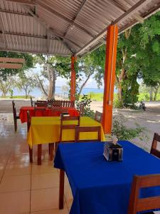 a patio with tables and chairs with the ocean in the background at Ernesto Hotel & Restaurante in El Remate