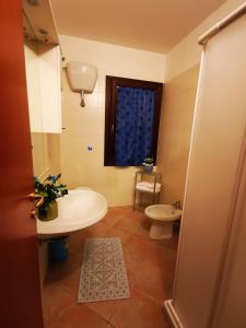 
a bathroom with a toilet, sink, and mirror at Casa Martina in Pula
