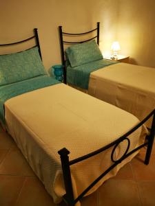 
two beds in a room with a blue wall at Casa Martina in Pula
