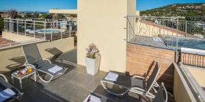 a balcony with tables and chairs and a swimming pool at La Bastide de l'Oliveraie in Cannes +67 photos