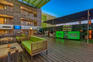 an outdoor deck with tables and green furniture at Lexen Hotel - North Hollywood Near Universal Studios in North Hollywood