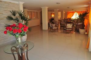 a vase of flowers on a glass table in a living room at Hotel da Montanha in Miguel Pereira