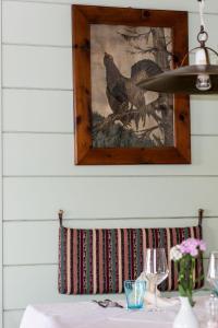 einen Tisch mit einem Bild von Hühnern an der Wand in der Unterkunft Gasthof zur Krone in Aldino