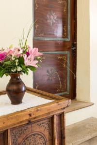 un vase de fleurs sur une table à côté d'une porte dans l'établissement Gasthof zur Krone, à Aldino