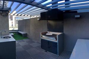 - une cuisine avec un grill au milieu d'une pièce dans l'établissement Acogedor Depto. a un costado de Clínica Las Condes, à Santiago