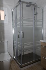 a glass shower in a bathroom with a toilet at Moderno,tranquilo, entrada autónoma y fácil aparcamiento. in Madrid
