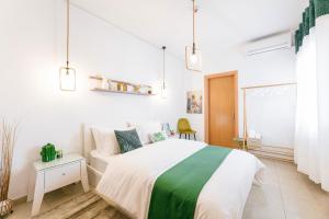 ein weißes Schlafzimmer mit einem grünen und weißen Bett in der Unterkunft Grand Lux Apartment in Serres