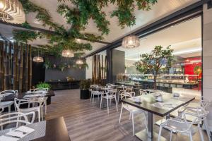 un restaurant avec des tables, des chaises et un comptoir dans l'établissement RR Hotel da Rocha, à Portimão