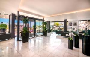 a lobby with potted plants in a building at RR Hotel da Rocha in Portimão +37 photos