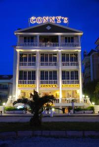 a building with a sign on top of it at night at Conny's Hotel (Adult Only) +18 in Side