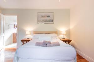 a bedroom with a large white bed with two lamps at Álaind Lodges, Sneem in Sneem