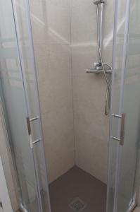 um chuveiro com uma porta de vidro na casa de banho em Moderno,tranquilo, entrada autónoma y fácil aparcamiento. em Madri