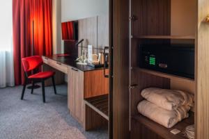 a hotel room with a desk and a room at HP Park Plaza in Wrocław