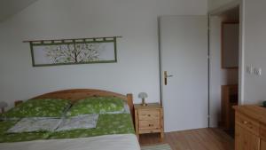 a bedroom with a bed with a green comforter at Ferienwohnungen Klammsteiner in Lienz