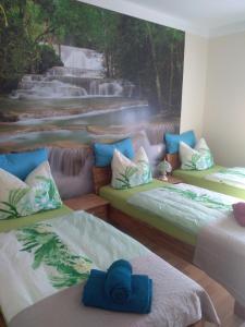 Zimmer mit 3 Betten und einem Wasserfall im Hintergrund in der Unterkunft Ferienwohnung " Mondschein" Lausitzer Seenland- 80qm mit Garten in Drochow