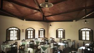 a dining room with tables and chairs and windows at Pousada Ecológica das Bromélias in Morro do Chapéu