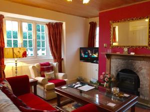 a living room with red walls and a fireplace at Gatekeepers Lodge @ Plas Dinas in Caernarfon