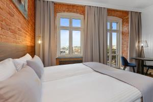 a bedroom with a large white bed and a window at Aparthotel Krzywa Kamienica in Łódź +54 photos