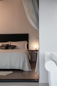 een slaapkamer met een wit bed en een bijzettafel bij La Maggiolina Country House in Montelabbate