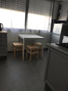 une cuisine avec une table, deux chaises et une table dans l'établissement APPART PORT DU CANAL, à Dijon