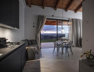 a kitchen and living room with a table and chairs at La Maggiolina Country House in Montelabbate