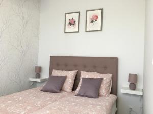 a bedroom with a bed with two pink pillows at Apartament Gold Triventi in Karpacz