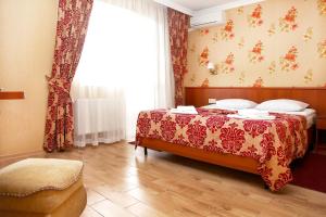 a bedroom with a bed and a large window at Hotel Lensis in Adler