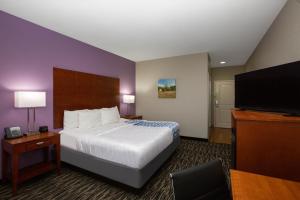 ein Hotelzimmer mit einem Bett und einem Flachbild-TV in der Unterkunft La Quinta by Wyndham Tupelo in Tupelo