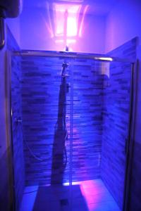 eine beleuchtete Dusche in einem Zimmer mit Ziegelwand in der Unterkunft B&B Magma in Ercolano