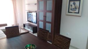 une salle à manger avec une table, des chaises et une télévision dans l'établissement vivienda vacacional Maravillosa, à Candelaria