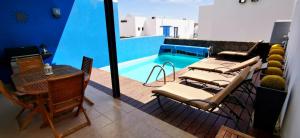 a balcony with chairs and a swimming pool at Villa Mariña piscina climatizada opcional y 2 bicis gratuitas in Playa Blanca