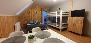 Zimmer mit einem Esstisch und einem Schlafzimmer mit Etagenbetten. in der Unterkunft Pokoje Przy Polanie in Stronie Śląskie