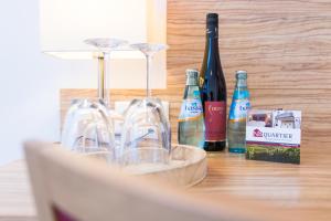 a table with wine glasses and bottles of wine at N8 Appartment-Hotel by Villa-Dörr in Wörrstadt