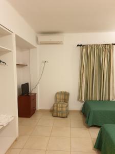 a bedroom with a bed and a chair and a window at HOSTAL MARACAIBO in Can Pastilla