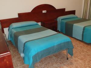 Tempat tidur dalam kamar di HOSTAL MARACAIBO