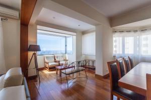 sala de estar con mesa, sillas y ventana grande en Deluxe Marina Apartment - Azorean Butler en Ponta Delgada