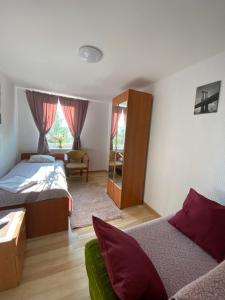 a bedroom with two beds and a couch in it at Hostel Piaseczno in Piaseczno