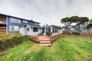 a house with a wooden deck in the yard at The Best Little Beach House on the Oregon Coast! in Lincoln Beach