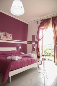ein lila Schlafzimmer mit einem Bett und einem Tisch in der Unterkunft B&B Magma in Ercolano