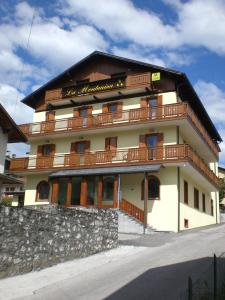 a building with wooden balconies on the side of it at Hotel La Nuova Montanina in Auronzo di Cadore