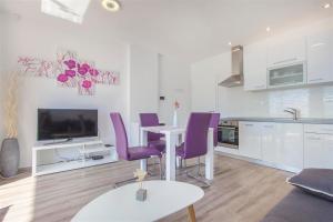 a kitchen and living room with a table and purple chairs at Villa top of Murter, one bedroom apartment in Murter