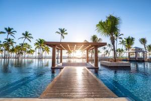 une piscine dans un complexe avec des palmiers et une jetée dans l'établissement Hyatt Zilara Cap Cana - Adults Only, à Punta Cana