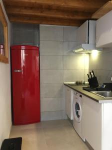 La cocina está equipada con nevera roja y lavadora. en Cathedral Studio, en Las Palmas de Gran Canaria
