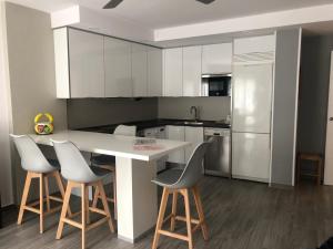 eine Küche mit weißen Schränken sowie einem weißen Tisch und Stühlen in der Unterkunft Apartamento Marbore (Torla-Ordesa) in Torla-Ordesa