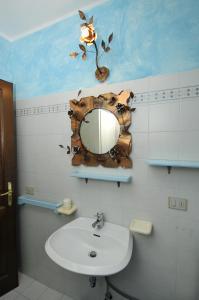 a bathroom with a mirror and a sink at ISS Travel, Villa Fiorita - 800 m from La Cinta beach in San Teodoro