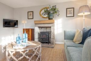 sala de estar con sofá y chimenea en Tucking Mill View- Self Catering, en Bath