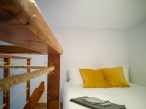 Un dormitorio con una cama con almohadas amarillas. en Cathedral Studio, en Las Palmas de Gran Canaria