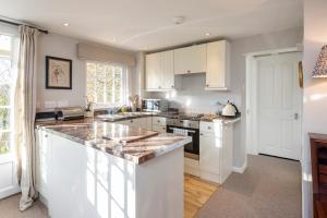 a kitchen with white cabinets and a marble counter top at Tucking Mill View- Self Catering in Bath